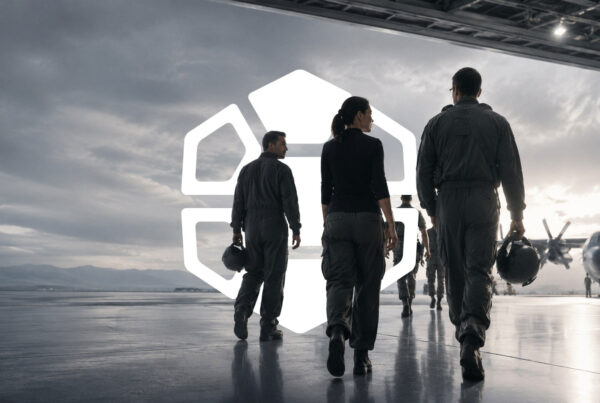Defense aviation team walking through an aircraft hangar beneath the Diamondback Solutions logo