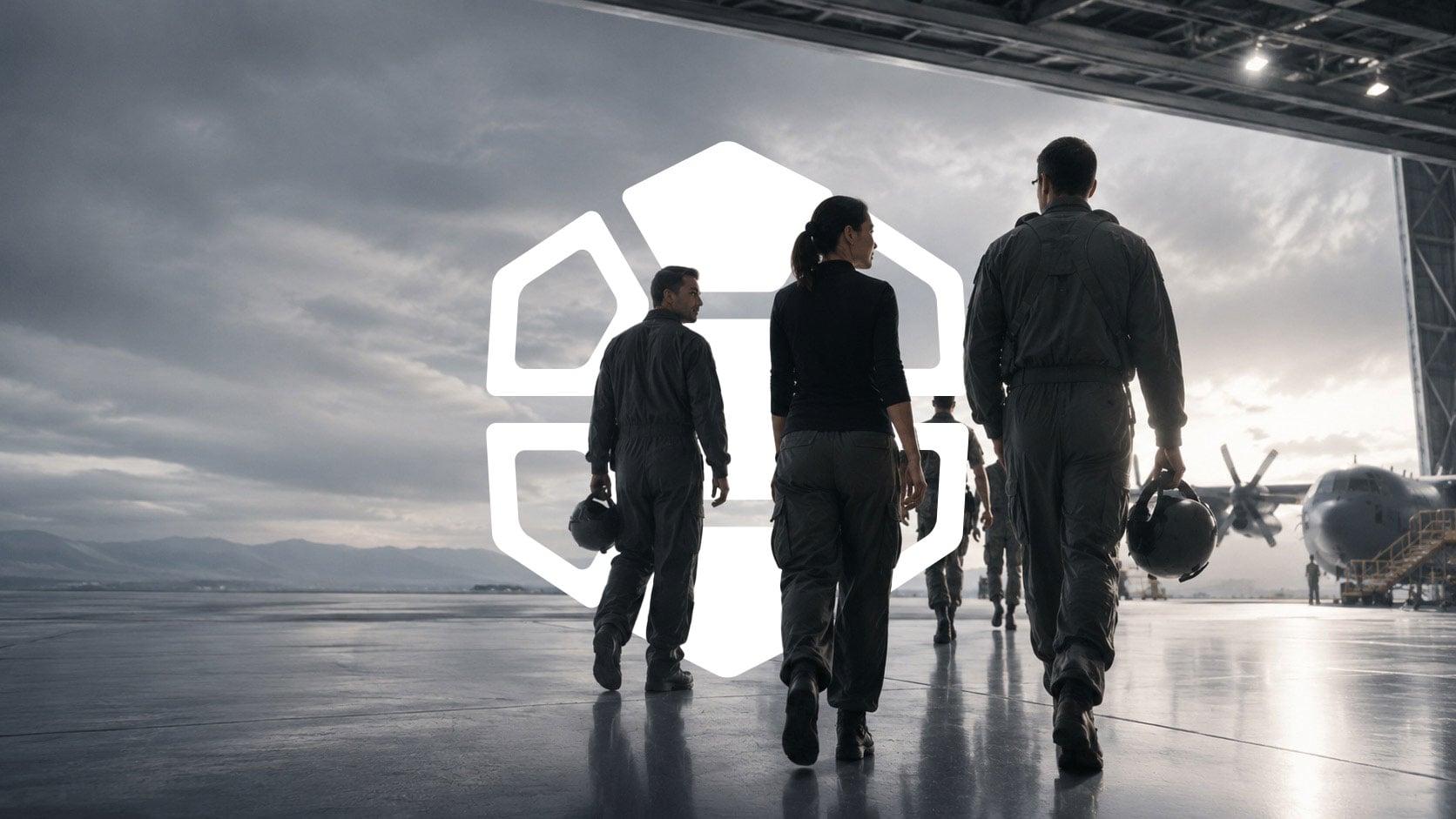 Defense aviation team walking through an aircraft hangar beneath the Diamondback Solutions logo